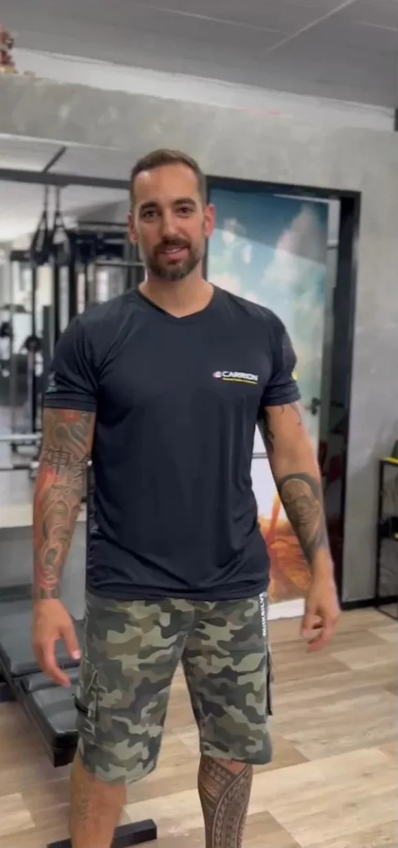 André Carrion no estúdio, de camiseta preta Carrion e bermuda camuflada